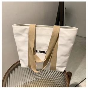 Detail of canvas tote bag showing the exterior pocket and SIJICHA logo on the side
