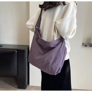 Detailed back view of a purple canvas crossbody bag with adjustable wide strap for daily use