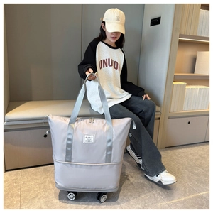 Close-up of light gray waterproof oxford travel bag with rolling wheels and sturdy handles