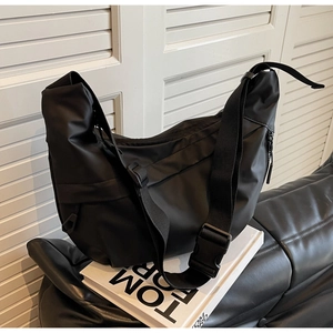 Detail of black nylon crescent bag featuring adjustable strap and matte fabric texture