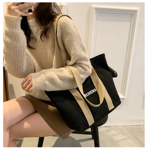 Close-up of a black canvas tote bag with beige straps and white SIJICHA logo detail