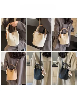 Detail view of stylish bucket bag in three colors with silk scarf handle and strap