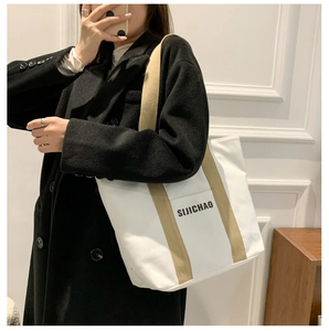 Mirror selfie showing large canvas tote bag with khaki strap for daily commute