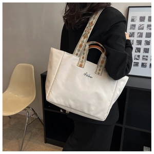 Dettaglio borsa tote in nylon bianco con manici geometrici e tracolla larga rimovibile