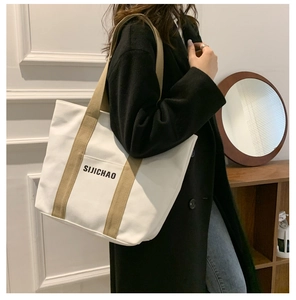 Detail of canvas tote bag with SIJICHAO lettering and khaki strap for daily commute