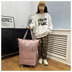 Pink waterproof Oxford cloth travel bag showing silent universal wheels and expandable bottom layer