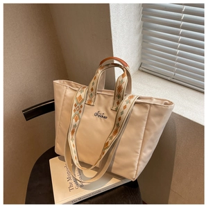 Dettaglio della borsa tote in nylon bianco crema con spalline ricamate geometriche