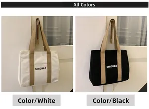 Detail view of canvas tote bags in white and black with khaki straps hanging on a hook