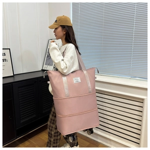 Detailed view of pink expandable travel bag with multi-layer zippers and four swivel wheels