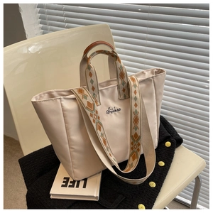 Dettaglio della borsa tote beige in nylon con ricamo Sijichao e tracolla tessuta geometrica