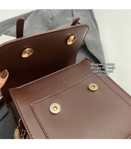 Detail of dark brown leather backpack featuring magnetic buckles and front pocket