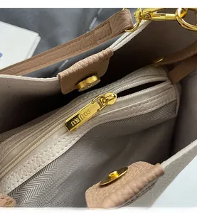 Close-up of leather handbag interior showing SOUKU metal zipper pocket and herringbone lining