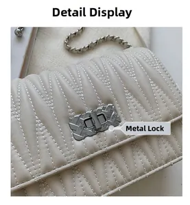 Detail of beige V-quilted handbag featuring a silver-tone metal twist lock closure