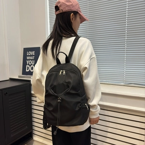 Large capacity black nylon backpack with drawstring front pocket and dual zippers for women