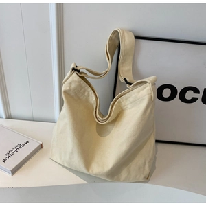 Detail of adjustable black shoulder strap buckle on a minimalist cream canvas tote bag
