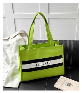Détail du sac cabas en toile vert vif avec rayures noires et blanches et anses solides