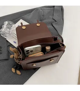 Detail view of the spacious inner compartment of this brown PU crossbody bag for storage
