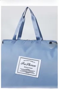 Detail of blue oxford travel bag showing durable twill texture and woven logo patch