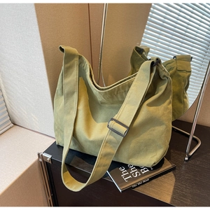 Detail of adjustable wide shoulder strap on army green canvas hobo crossbody bag