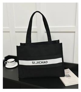 Gros plan du sac cabas en toile SI.JICHAO avec design contrasté noir et blanc et logo