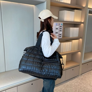 Grand sac bandoulière matelassé noir en oxford pour sport et voyage porté par un mannequin