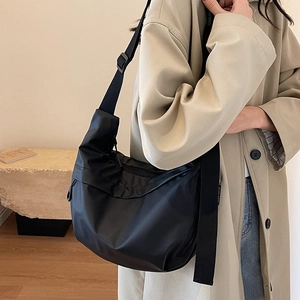 Minimalist black nylon crescent crossbody bag with adjustable wide strap for daily commute