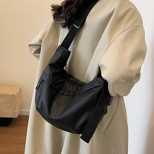 Minimalist black nylon dumpling bag with adjustable shoulder strap and large capacity