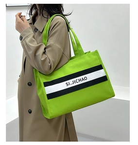 Détail du sac cabas en toile vert fluo avec sangle logo et grande capacité intérieure