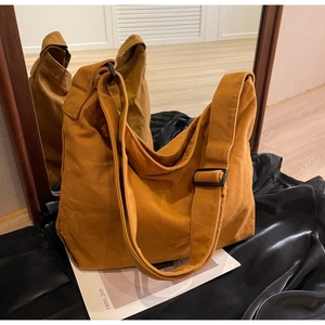 Detailed shot of yellow canvas tote bag featuring adjustable black strap and durable fabric