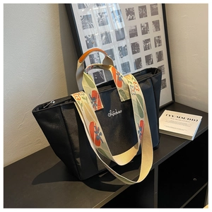 Dettaglio della borsa tote in nylon nero con tracolla floreale e cerniera in metallo argento