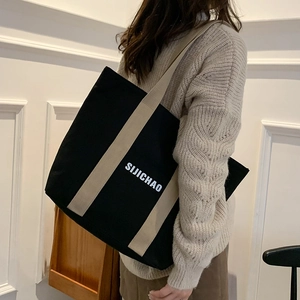 Large black canvas tote bag with SIJICHAO lettering and beige straps for daily commute