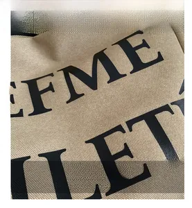 Vue détaillée de la texture du tissu en toile beige et de l'impression de lettres noires
