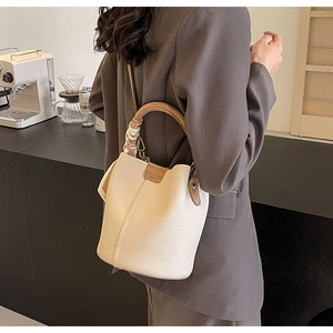 Chic off-white bucket bag with lychee texture leather and silk scarf handle detail