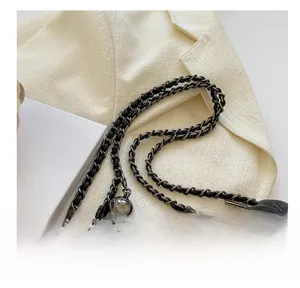 Detailed view of quilted black leather bag with silver ball charm and chain strap