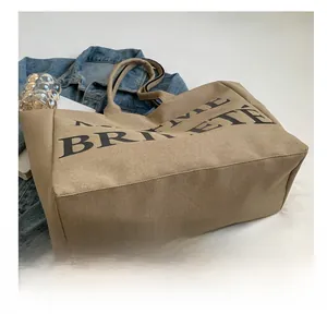 Gros plan du sac fourre-tout en toile kaki avec lettrage BRIVETE et détails du tissu