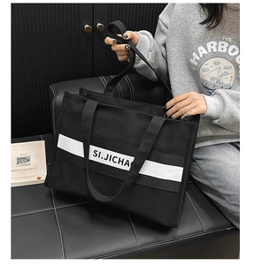 Détail du grand sac cabas en toile noire avec rayures blanches et poignées larges