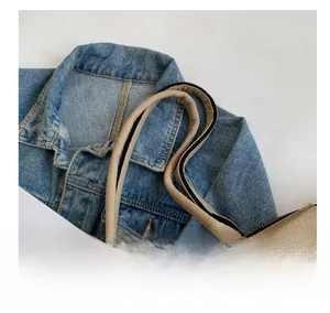 Détail des poignées tissées du sac cabas en toile et de la fermeture éclair en métal