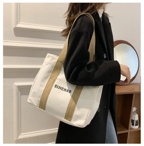 Detail of canvas tote bag with khaki strap showing premium texture and SIJICHAO print