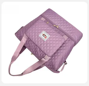 Detail view of purple quilted oxford fabric handbag with wide straps and zip pocket
