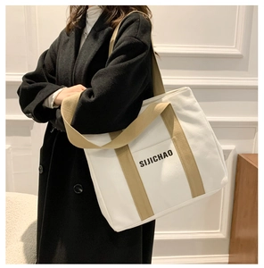 Close-up of white canvas tote bag with khaki straps and 'SIJICHAO' letter print