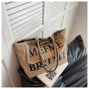 Détail du sac fourre-tout en toile kaki avec lettrage noir et fermeture éclair robuste