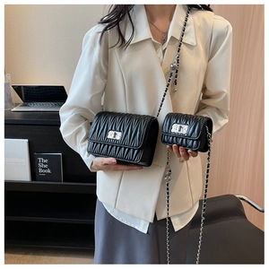 Detail of black quilted chain bags set with metallic twist lock and褶皱 leather texture