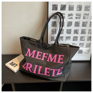 Gros plan du sac cabas en toile noire avec lettrage artistique rose et anses solides