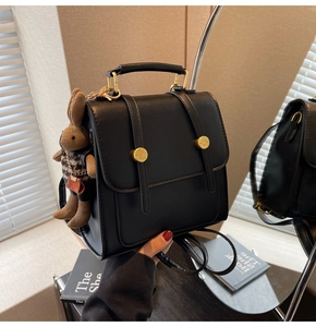 Detail of black PU leather multi-purpose backpack with bunny pendant and gold buckle