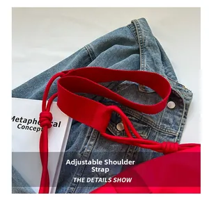 Detail of red nylon bag with wide adjustable strap and knotted rope design accent