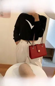 Detail view of red faux crocodile leather wedding bag with metal chain strap and clasp