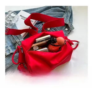 Interior detail of red nylon crossbody bag showing large capacity with daily essentials