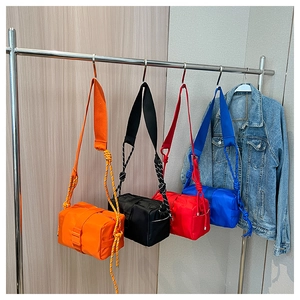 Detail of colorful nylon crossbody bags with unique braided rope straps and metal hooks