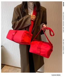Detail of bright red nylon cylindrical crossbody bags with wide straps and plastic buckles