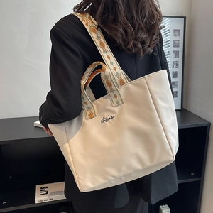 Grande borsa tote in nylon beige con tracolla intrecciata colorata e ricamo elegante